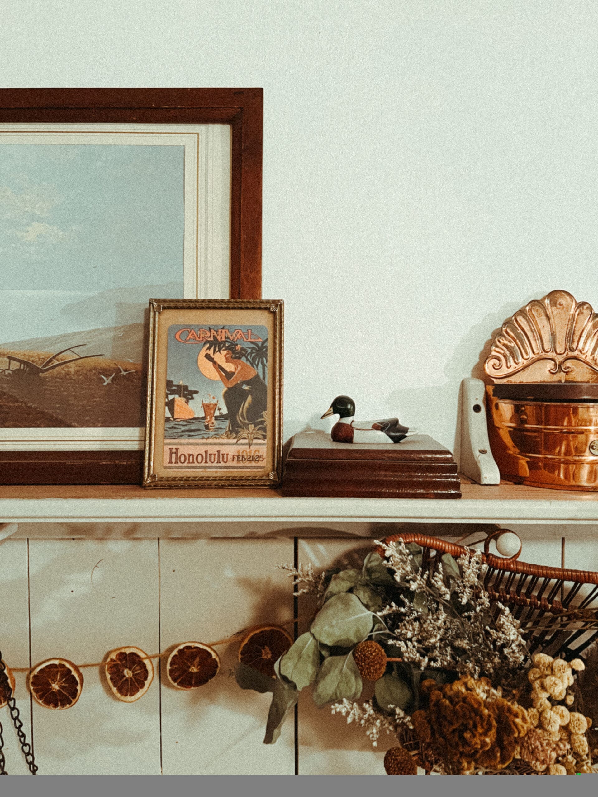 shelf with antique pictures and dried fruit and flowers