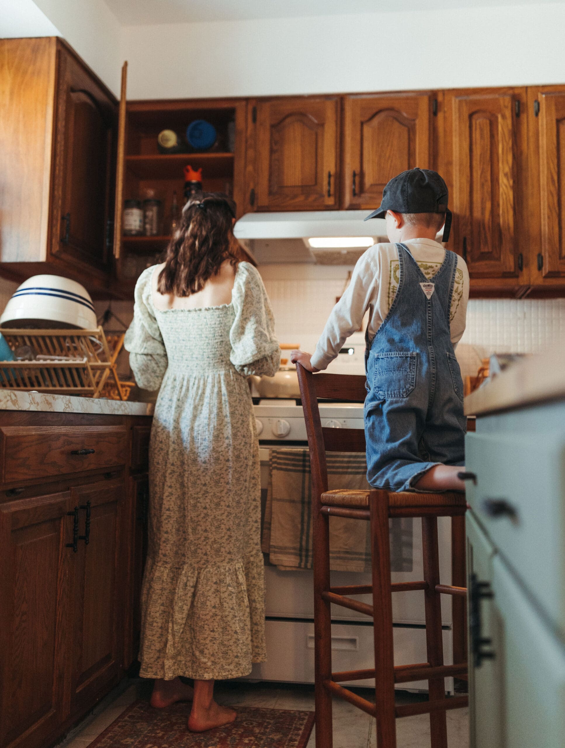 mother and son standing at the oven baking