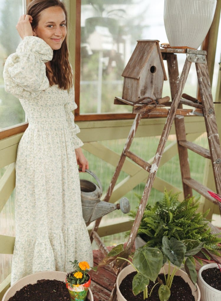 girl standing in greenhouse smiling