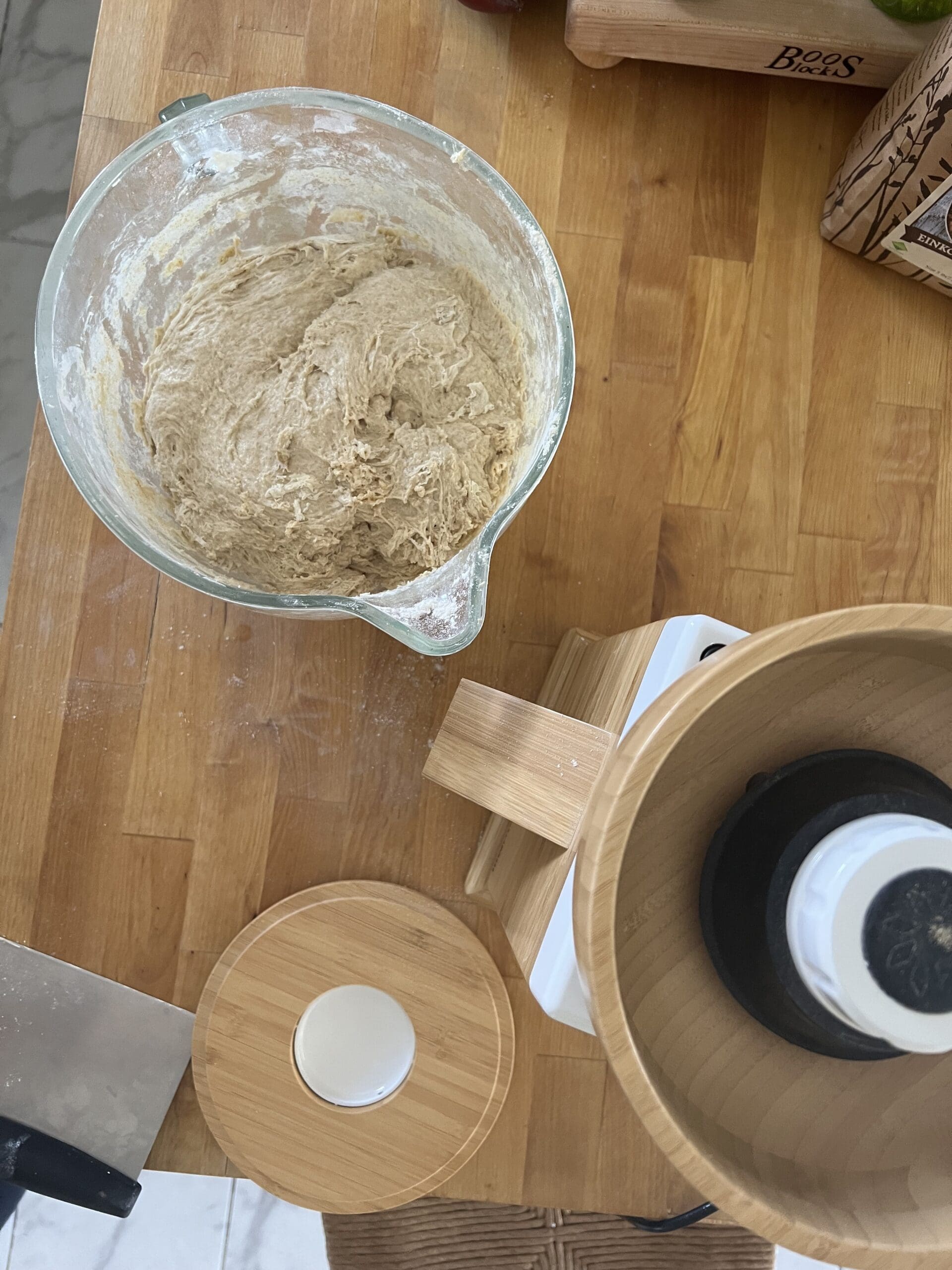 Flour mill sitting on counter with bowl of sourdough